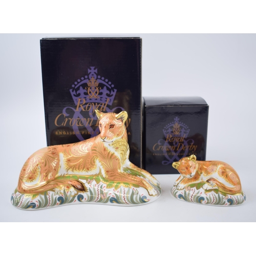 68 - Two Royal Crown Derby paperweights, Lioness with a Sleepy Lion Cub, gold stoppers and red printed ma... 