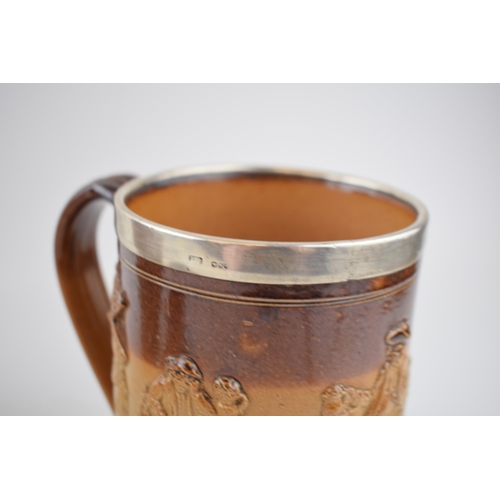 200 - A trio of stoneware items to include a silver rimmed Doulton Lambeth tankard, a large pouring jug, p... 