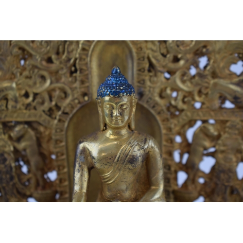 234 - Large reproduction Tibetan gilt bronze figure of a seated Tibetan buddha on a throne, 28cm tall.