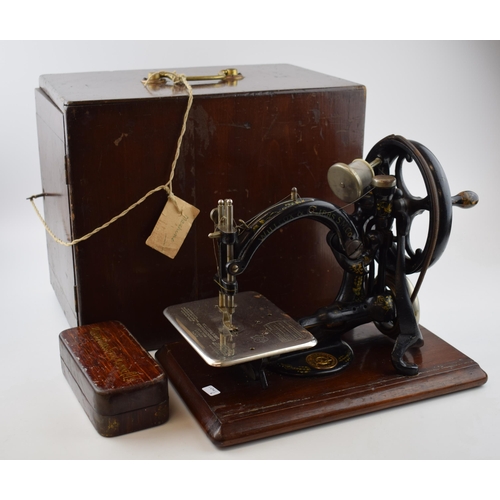 261 - Willcox & Gibbs sewing machine, hand propelled, with wooden carry case / box, with a box of accessor... 