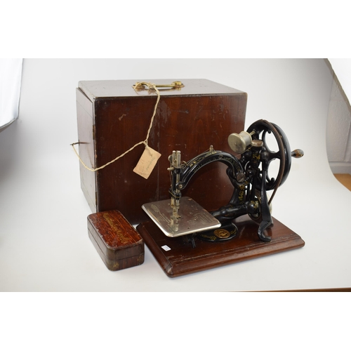 261 - Willcox & Gibbs sewing machine, hand propelled, with wooden carry case / box, with a box of accessor... 