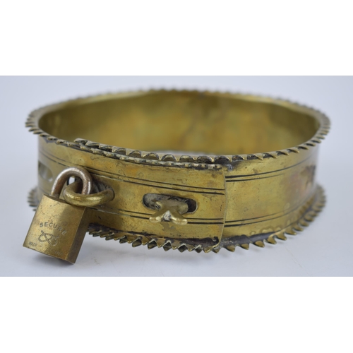 263 - An antique brass dog collar with decorative fixings and raised spiked pattern to outer edge. Diamete... 