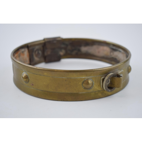 265 - An antique brass dog collar with ball decoration and sliding buckle.  Diameter 46cm.