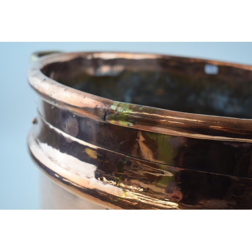 266 - Large Victorian copper basket with riveted joints with brass handles, 53cm diameter.