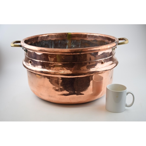 266 - Large Victorian copper basket with riveted joints with brass handles, 53cm diameter.