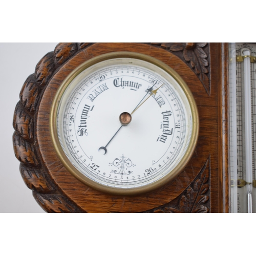 285 - Early 20th century wall hanging barometer clock with central thermometer, bevelled glass, in carved ... 