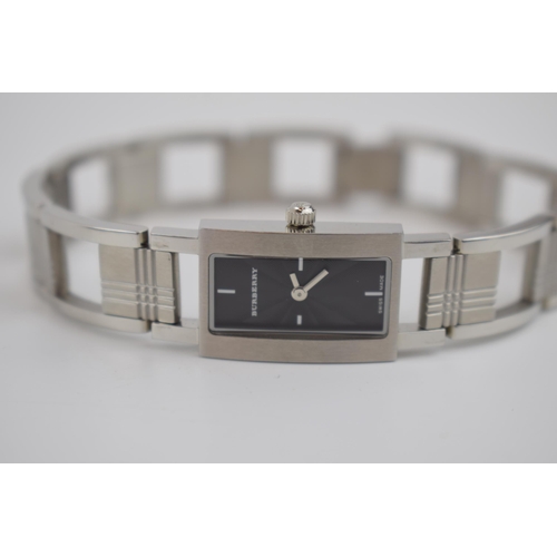 384 - A ladies Burberry fashion watch with Swiss quartz movement. Black rectangular dial with applied bato... 