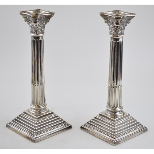 407 - Pair of corinthian column candlesticks  with weighted bases. Sterling silver. Hallmarked Birmingham,... 