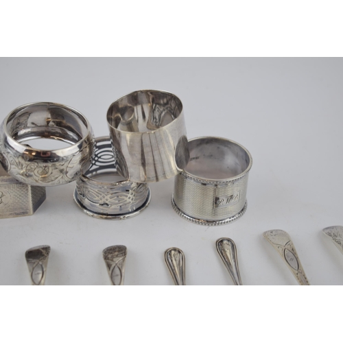 424 - A collection of sterling silver items to include 5 singular napkin rings with tea spoons, combined w... 