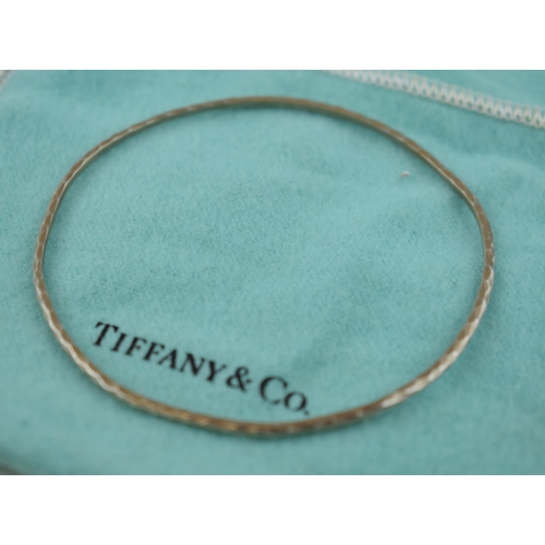 458 - Tiffany & Co hammered silver bangle, with original purchase receipt, 5.0 grams.