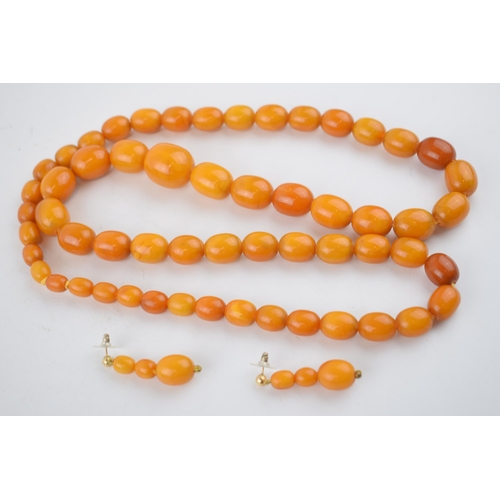 461 - A graduated set of butterscotch amber (or similar) beads, as a necklace, with a matching pair of ear... 