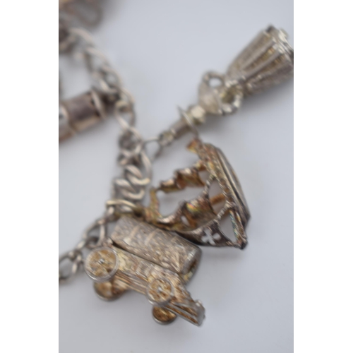 468 - Silver charm bracelet with charms to include an Airedale terrier, a bulldog, a galleon and others, 5... 