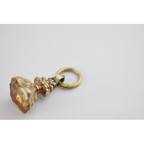 479 - Yellow metal (tests as 9ct gold) ornate fob with citrine style stone, 4.2 grams.