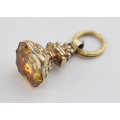 479 - Yellow metal (tests as 9ct gold) ornate fob with citrine style stone, 4.2 grams.