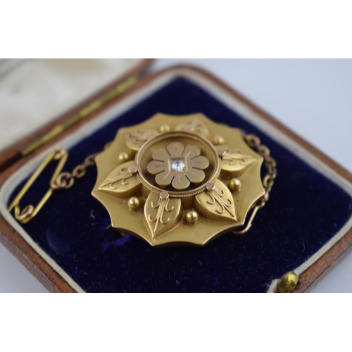 485 - 15ct gold brooch, in the form of a flower, with central diamond and locket reverse, with metal safet... 