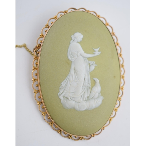 487 - 9ct gold framed Wedgwood cameo in early lime green colourway depicting a lady with a large bird, 65m... 