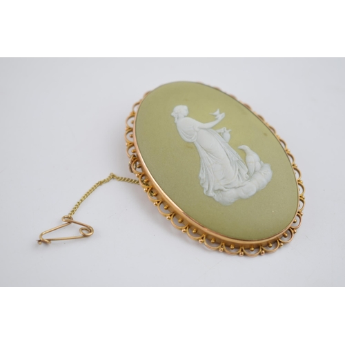 487 - 9ct gold framed Wedgwood cameo in early lime green colourway depicting a lady with a large bird, 65m... 