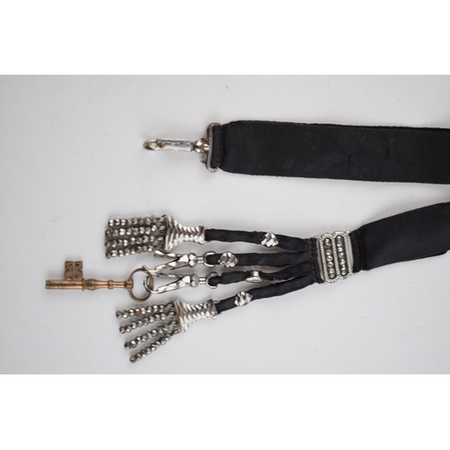 512 - Early Victorian chatelaine with cut steel decoration on black fabric, 25cm long.