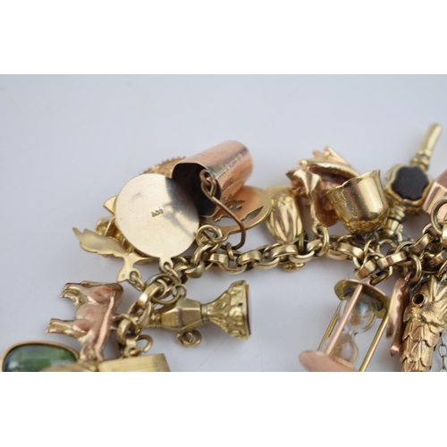 519 - 9ct gold charm bracelet with approximately 44 individual charms. Including a 22ct gold 1/3 Guinea co... 