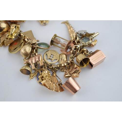 519 - 9ct gold charm bracelet with approximately 44 individual charms. Including a 22ct gold 1/3 Guinea co... 