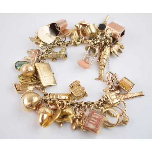 519 - 9ct gold charm bracelet with approximately 44 individual charms. Including a 22ct gold 1/3 Guinea co... 