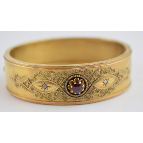 521 - 15ct gold (tests as) Egyptian Revival ladies bangle, set with diamonds and a large garnet with ornat... 