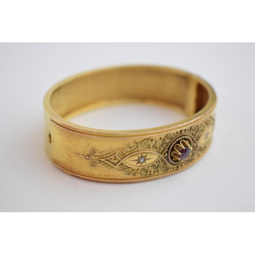 521 - 15ct gold (tests as) Egyptian Revival ladies bangle, set with diamonds and a large garnet with ornat... 