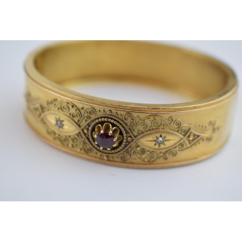 521 - 15ct gold (tests as) Egyptian Revival ladies bangle, set with diamonds and a large garnet with ornat... 