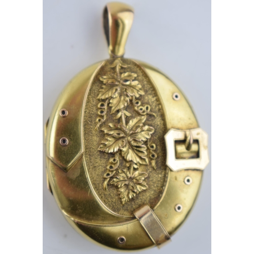 522 - 15ct gold locket with ornate decoration and belt buckle to front, gross 19.2 grams, glass and metal ... 