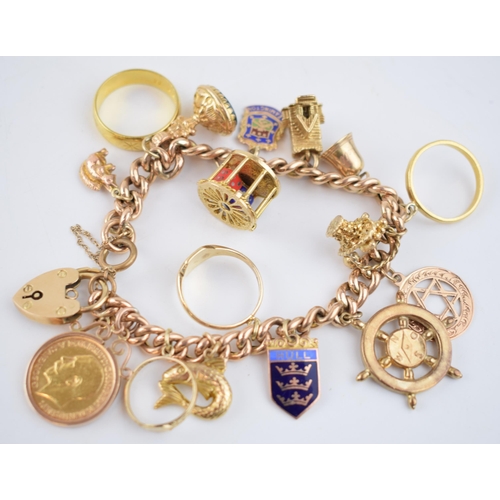 523 - 9ct rose gold charm bracelet with an interesting collection of charms to include a 22ct gold 1912 ha... 