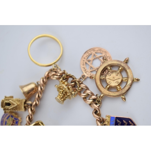 523 - 9ct rose gold charm bracelet with an interesting collection of charms to include a 22ct gold 1912 ha... 