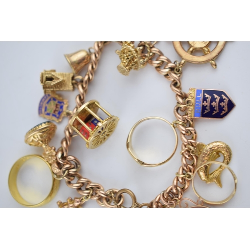 523 - 9ct rose gold charm bracelet with an interesting collection of charms to include a 22ct gold 1912 ha... 