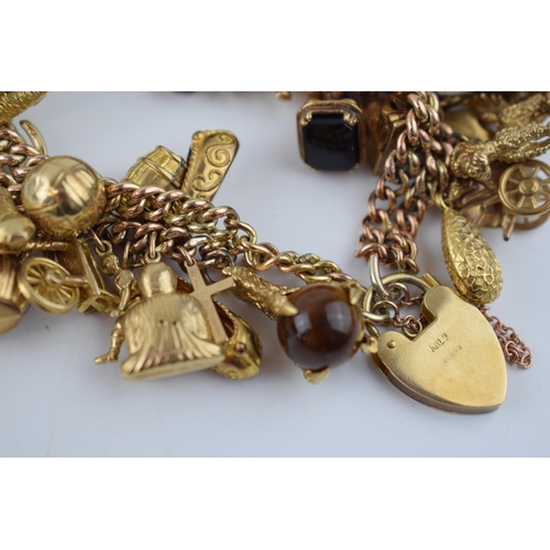 525 - 9ct gold double link charm bracelet, complete with over 40 charms, to include a fob, an eagle's claw... 