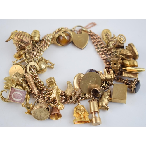 525 - 9ct gold double link charm bracelet, complete with over 40 charms, to include a fob, an eagle's claw... 