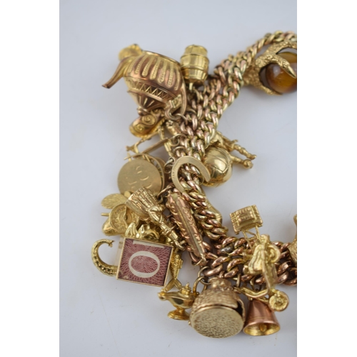 525 - 9ct gold double link charm bracelet, complete with over 40 charms, to include a fob, an eagle's claw... 