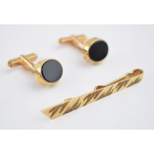 542 - A 9ct gold tie pin with engraved decoration together with a 9ct gold pair of cufflinks set with onyx... 