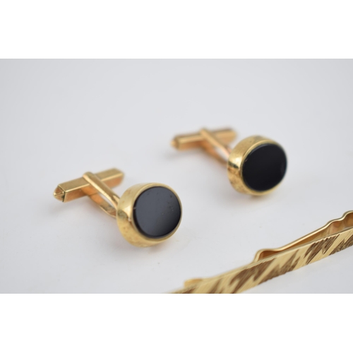 542 - A 9ct gold tie pin with engraved decoration together with a 9ct gold pair of cufflinks set with onyx... 