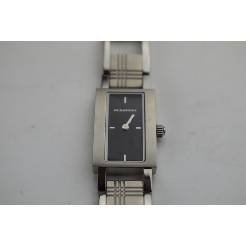 384 - A ladies Burberry fashion watch with Swiss quartz movement. Black rectangular dial with applied bato... 