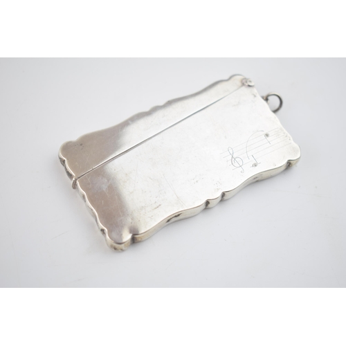 559 - Silver card case with musical engraving, 50.0 grams, Birmingham 1913.