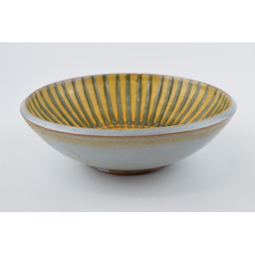 68 - A studio pottery stoneware bowl, with green on mustard yellow decoration, 20.5cm diameter, stamped '... 