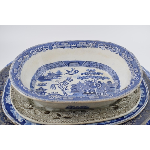 112 - A group of 19th century blue and white pottery Willow pattern platters and other similar. (q)