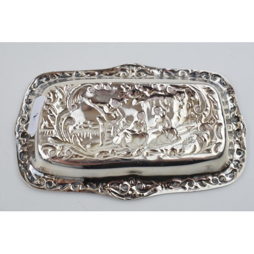 287 - Hallmarked silver heavily embossed pin tray with a romantical scene of a gentleman playing music for... 