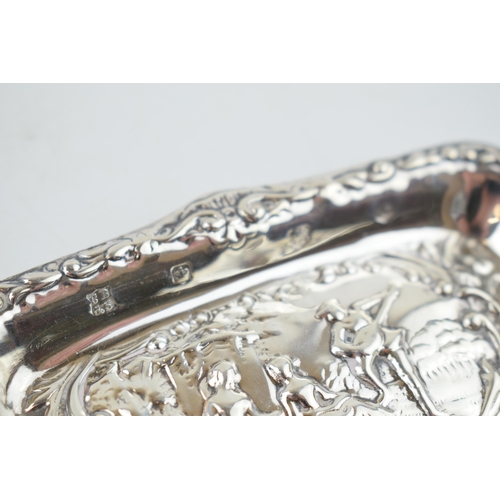 287 - Hallmarked silver heavily embossed pin tray with a romantical scene of a gentleman playing music for... 