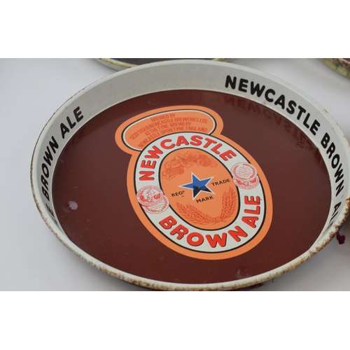 300 - Four tin Newcastle Brown Ale advertising pub trays. Three of the same design with brown ground and a... 