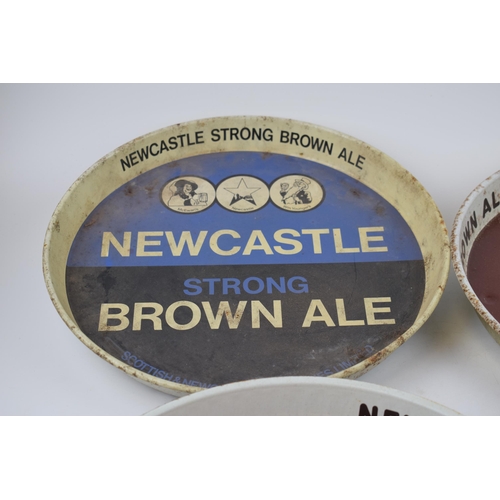 300 - Four tin Newcastle Brown Ale advertising pub trays. Three of the same design with brown ground and a... 