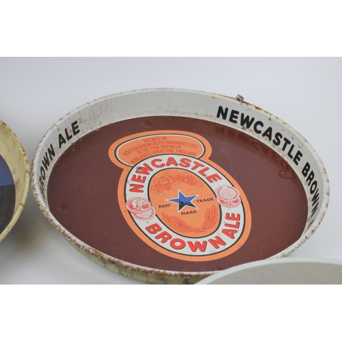 300 - Four tin Newcastle Brown Ale advertising pub trays. Three of the same design with brown ground and a... 