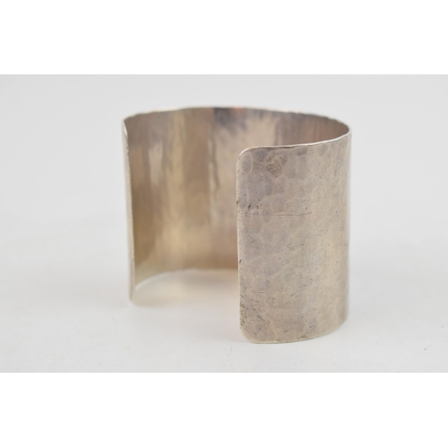 319 - Sterling silver hammered wide bangle, 65.2 grams, 52mm wide, London 2011, M C Hersey & Son Ltd (Stew... 