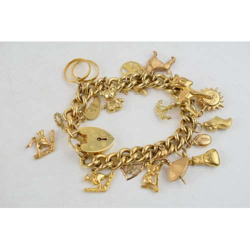 9ct yellow gold charm bracelet with padlock clasp and safety chain. To include 14 individual charms and one separate charm. Majority of charms are fully hallmarked. Also includes two high gold content rings (One marked 22ct) Weight 62.7 grams.