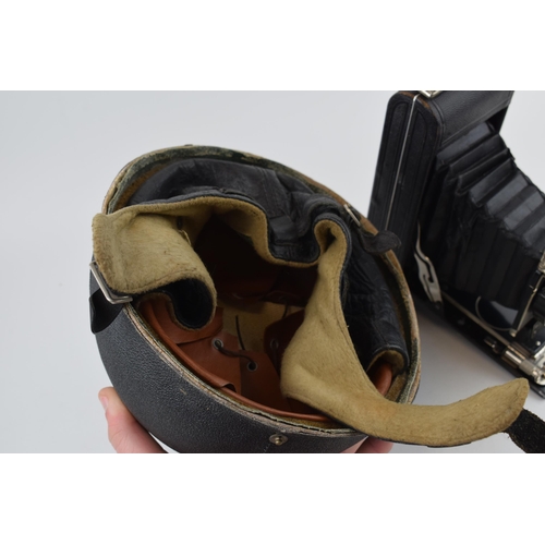 418 - A Slazenger Made in England Motorcycle helmet together with a vintage Kodak camera. (2)