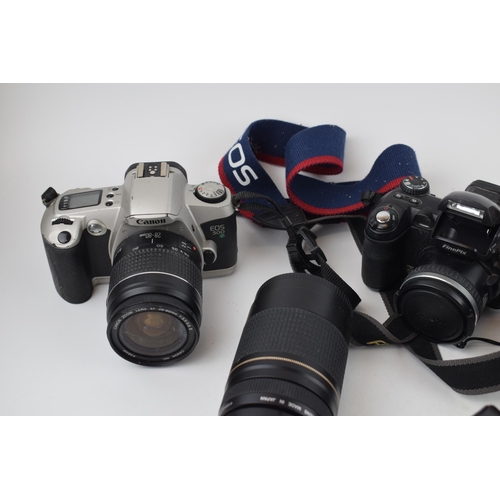 422 - A collection of vintage cameras and lenses to include Olympus OM10, Canon EOS and FinePix cameras to... 